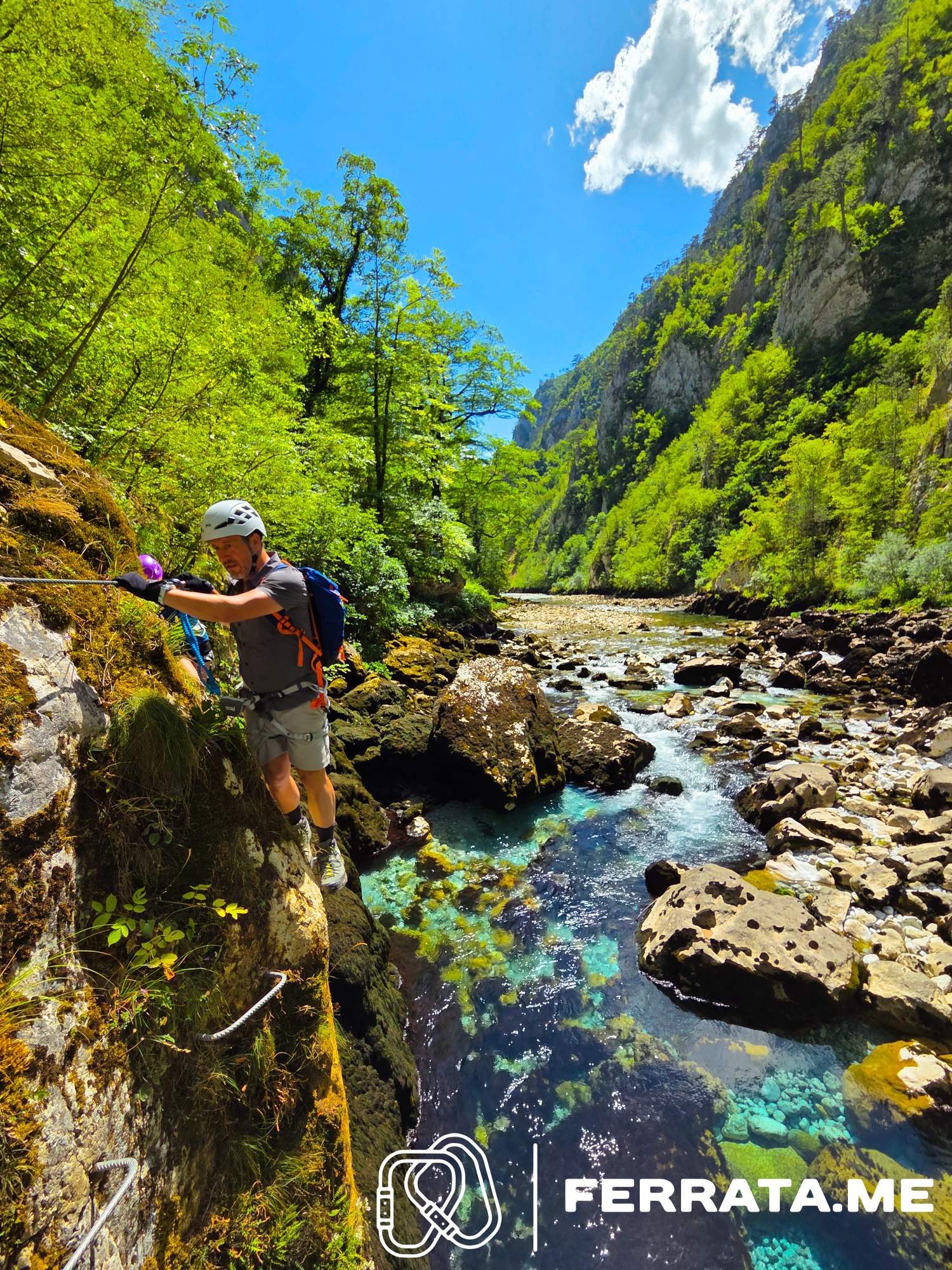 Climber on a steep graded via ferrata section with iron rungs and cable