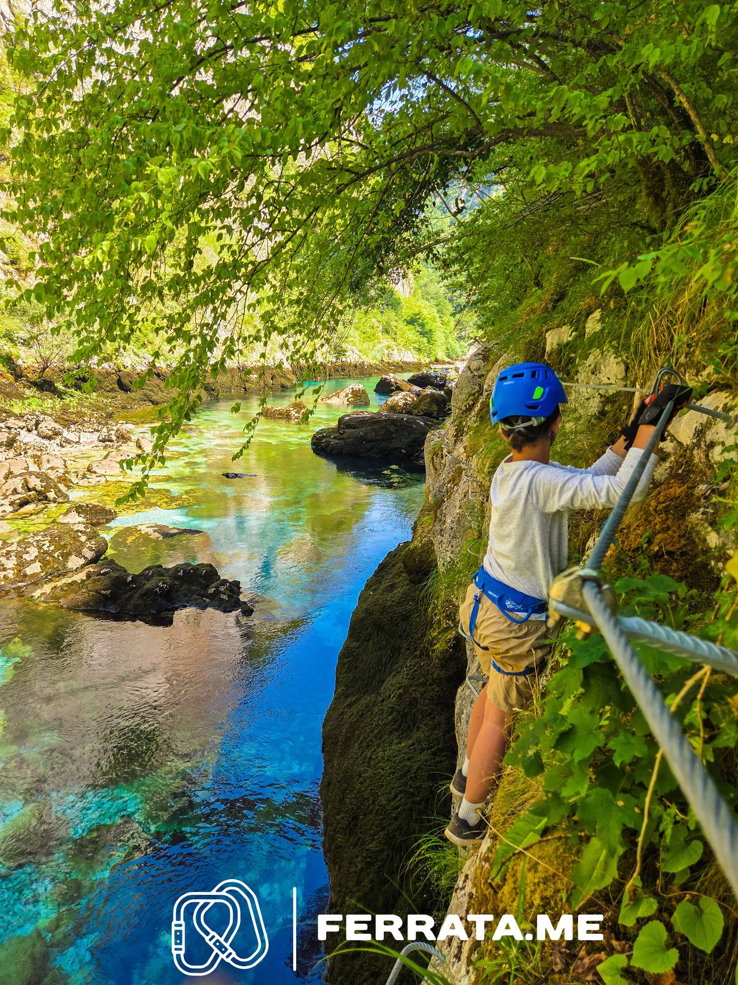 Via ferrata climber wearing helmet, harness and gloves on a sunny rock face